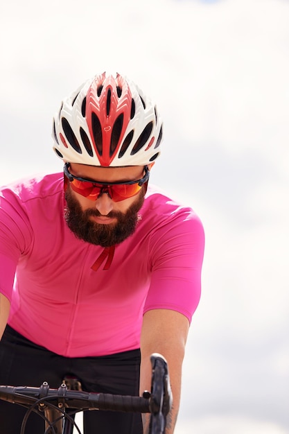 Foto apuesto joven ciclista monta una bicicleta