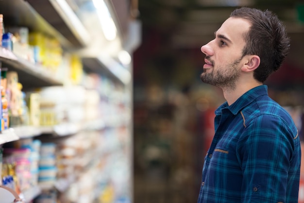 Apuesto joven para compras de frutas y verduras en el departamento de producción de una tienda de abarrotes Supermercado Shallow Deep Of Field