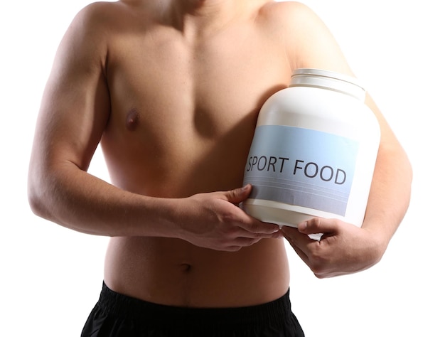 Apuesto joven deportista musculoso con alimentos proteicos aislado en blanco