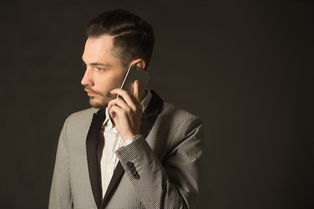 apuesto joven elegante en una chaqueta con un teléfono