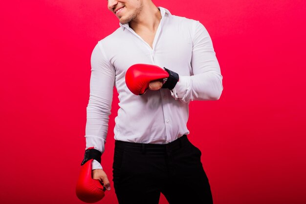 Apuesto joven empresario con guantes de boxeo studio fondo rojo.