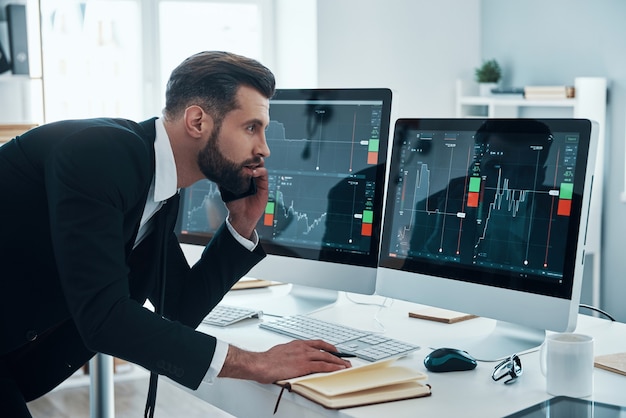 Apuesto joven empresario trabajando en el escritorio