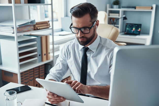 Apuesto joven empresario trabajando en el escritorio