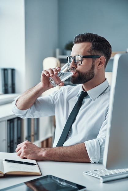 Apuesto joven empresario trabajando en el escritorio