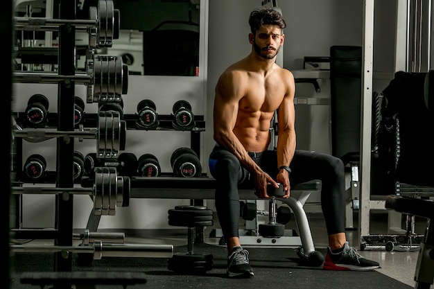 Apuesto joven entrenando en el gimnasio