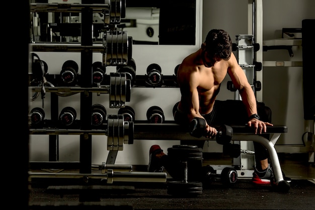 Apuesto joven entrenando en el gimnasio