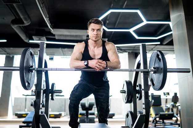 Apuesto joven fuerte en el gimnasio