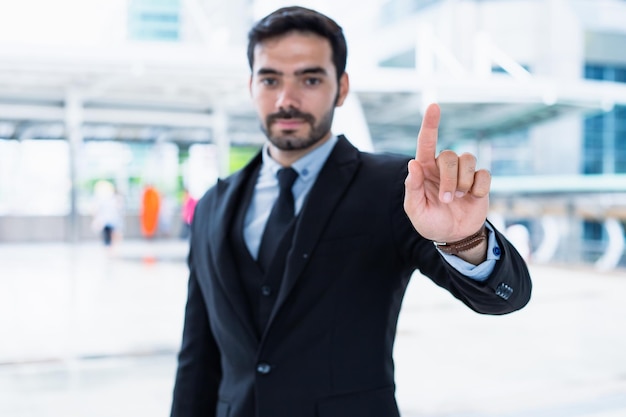 Un apuesto joven hombre de negocios con un traje exitoso presenta su trabajo de manera confiable