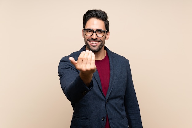 Apuesto joven invitando a venir con la mano. Feliz de que hayas venido