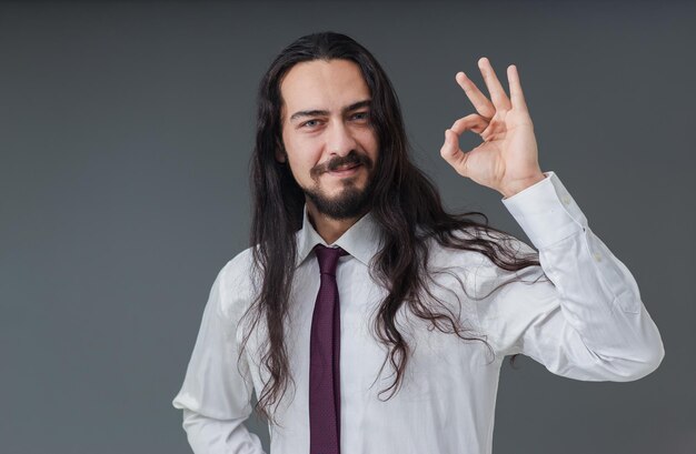 Un apuesto joven italiano está haciendo gestos de que todo está bien y que está bien con las manos