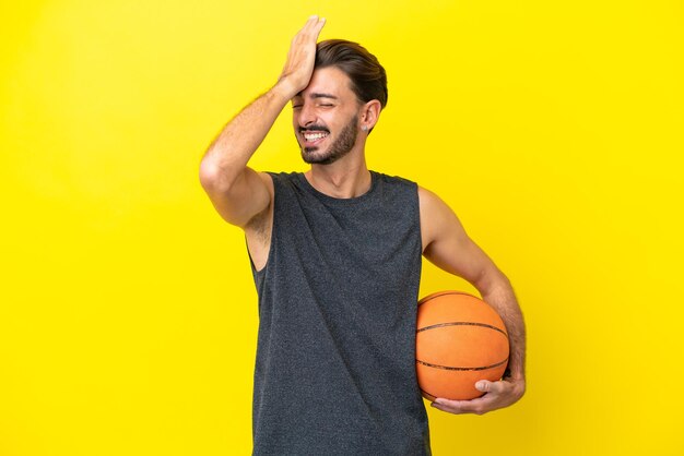 Un apuesto joven jugador de baloncesto aislado de fondo amarillo se ha dado cuenta de algo y tiene la intención de encontrar la solución