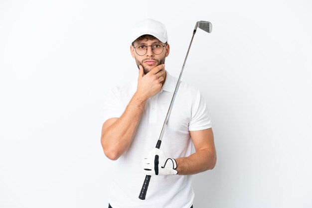 Apuesto joven jugando al golf aislado sobre fondo blanco pensando