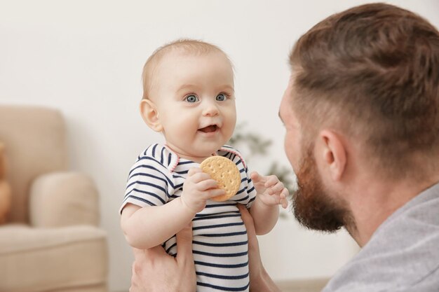 Apuesto joven jugando con lindo bebé en casa