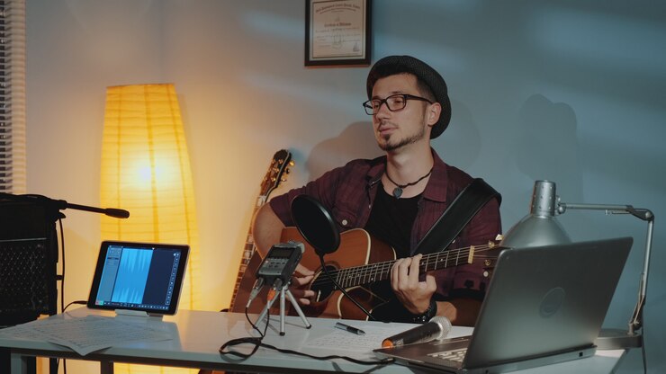 Foto apuesto joven músico grabando su nueva canción en el estudio casero