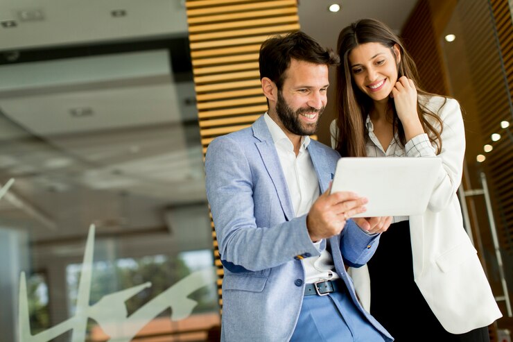 Foto apuesto joven pareja con tableta en la oficina moderna