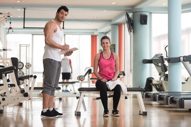 Apuesto joven de pie fuerte en el gimnasio y flexionando los músculos Muscular culturista atlético Modelo de fitness posando después de los ejercicios