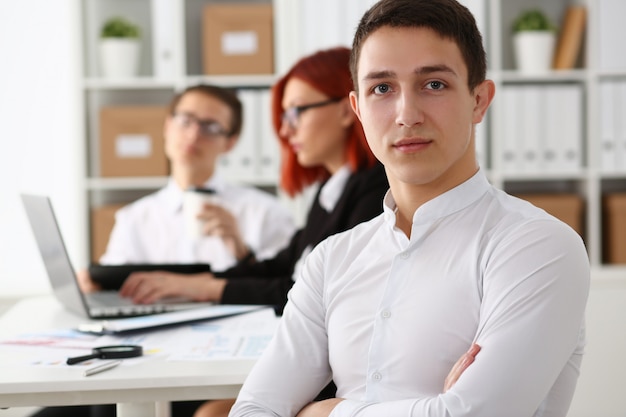 Apuesto joven que trabaja con colegas en la oficina