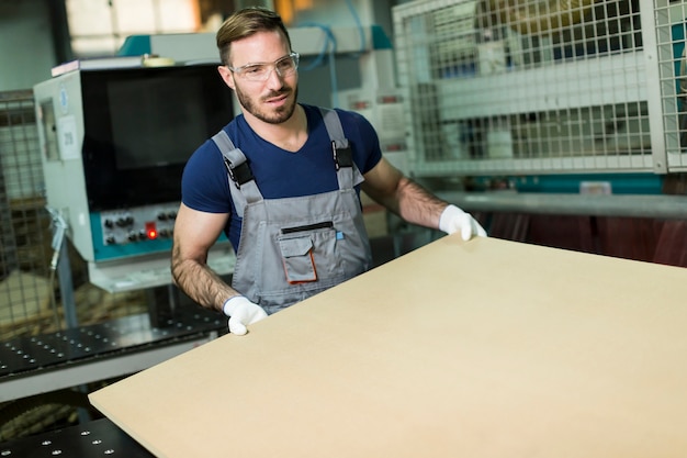 Apuesto joven que trabaja en la fábrica de muebles