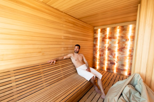 Apuesto joven relajándose en la sauna