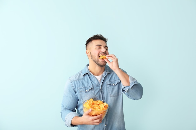 Apuesto joven con sabrosas papas fritas en color