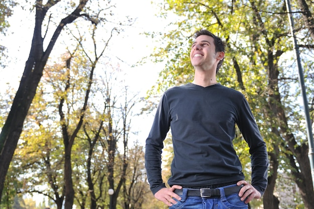 Apuesto joven sonriendo al aire libre en la naturaleza