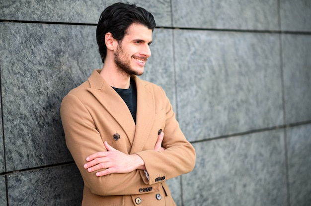 Apuesto joven sonriendo al aire libre en ropa elegante casual