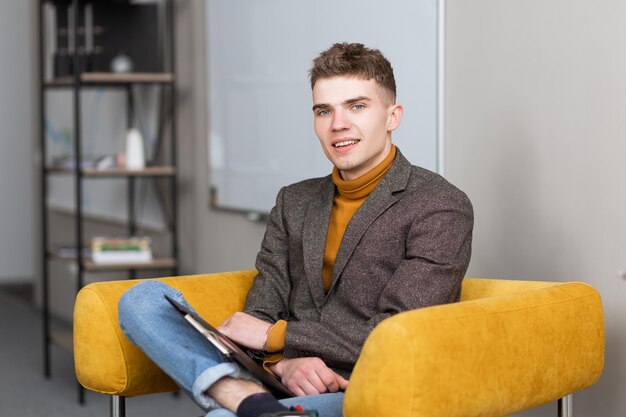 Apuesto joven sonriendo a la cámara y rellenando formularios