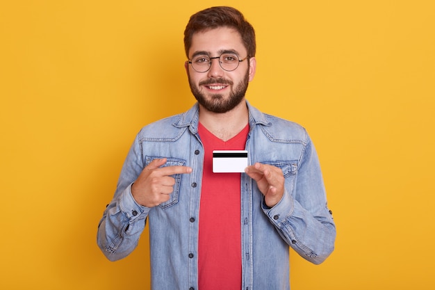 Apuesto joven sonriente con cuentas con gafas