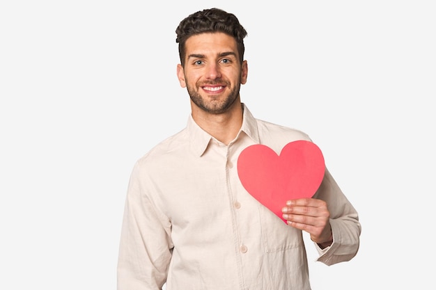 Foto apuesto joven sosteniendo un corazón de papel símbolo de amor