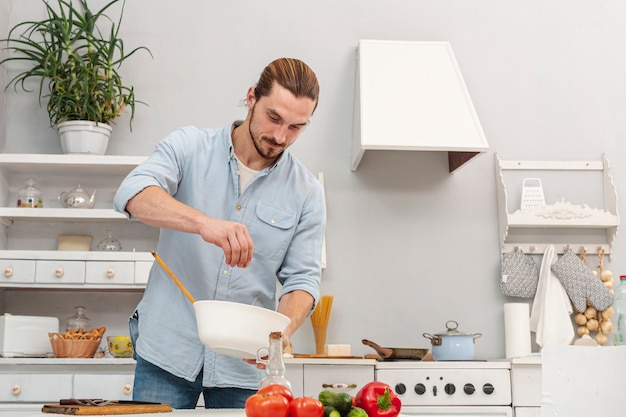 Foto apuesto joven sosteniendo un tazón