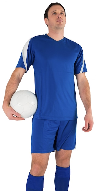 Foto apuesto jugador de fútbol sosteniendo la pelota