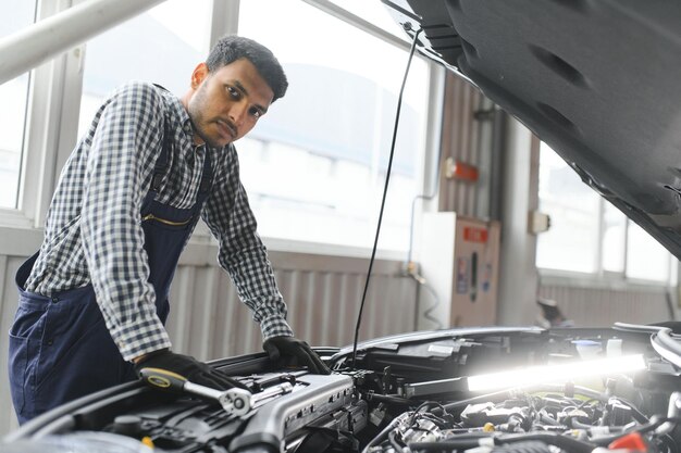 Apuesto mecánico de automóviles indio en el servicio de automóviles