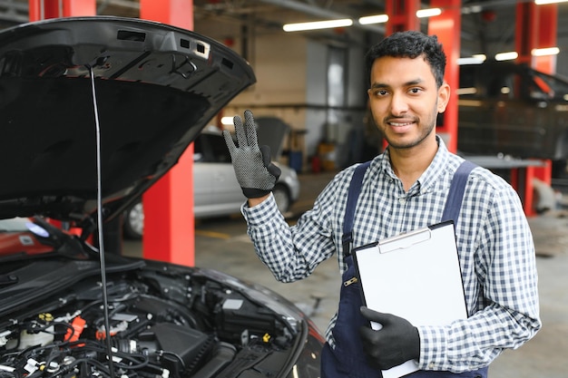 Apuesto mecánico de automóviles indio en el servicio de automóviles