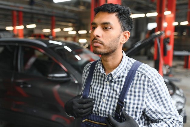 Apuesto mecánico de automóviles indio en el servicio de automóviles