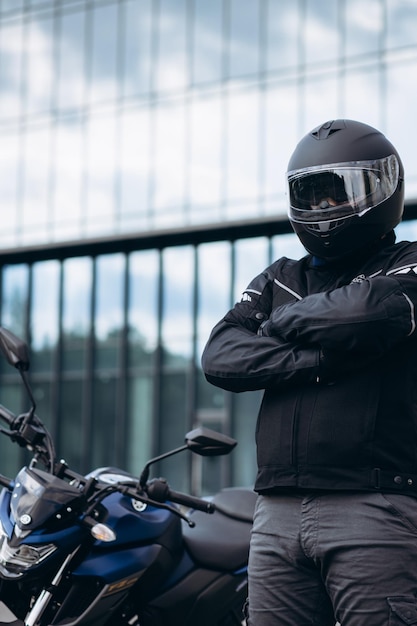 Apuesto motociclista en su moto montando en la ciudad