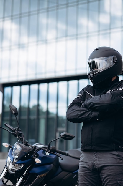 Apuesto motociclista en su moto montando en la ciudad