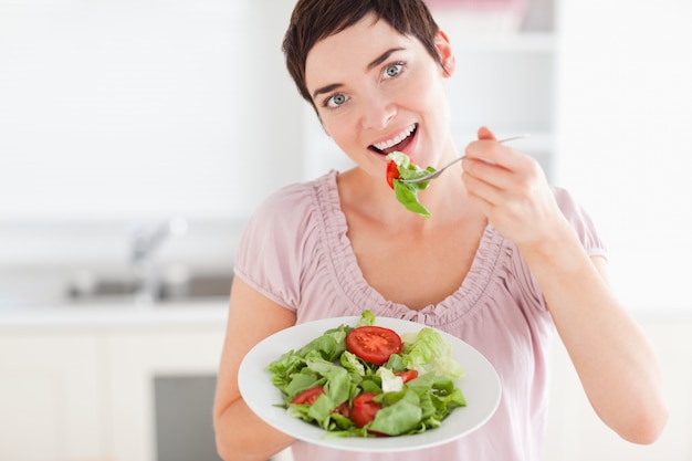 Apuesto mujer comiendo ensalada