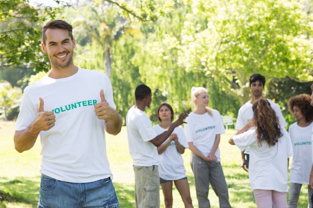 Apuesto voluntario mostrando los pulgares para arriba