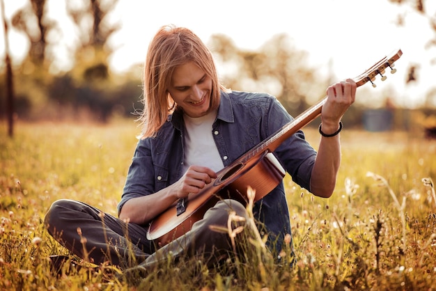 Apuestos jóvenes tocando la guitarra