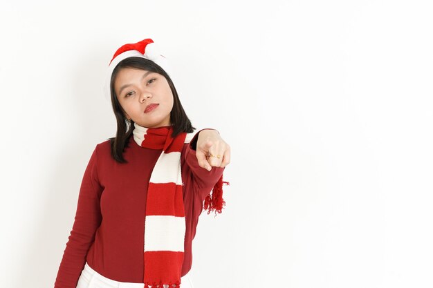 Apuntando a usted de hermosa mujer asiática con cuello alto rojo y gorro de Papá Noel aislado en blanco