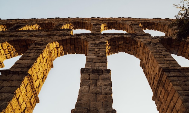 Aqueduto de Segóvia ao pôr do sol de baixo olhando para cima