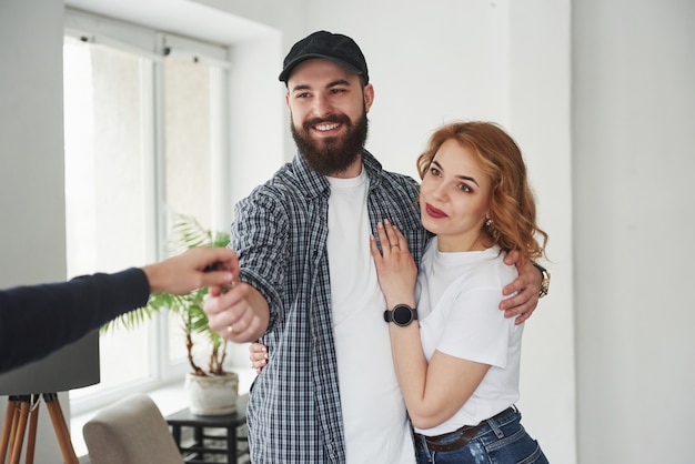 Aquí tienes tus llaves. Pareja feliz juntos en su nueva casa. Concepción de mudanza