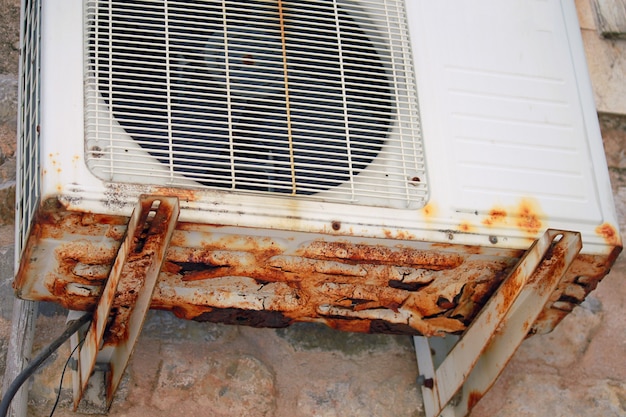 Ar condicionado antigo com corrosão, na parede, ao ar livre