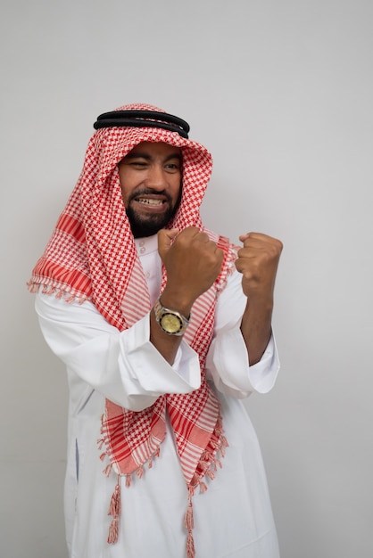 Un árabe con turbante se siente feliz con el movimiento de sus manos apretadas con entusiasmo.