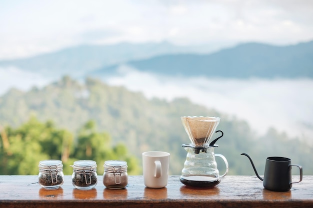 Arabica-Kaffeebrauen von Vintage-Kaffee-Tropf-Geräten auf Holztisch am Morgen mit Berg- und Naturhintergrund