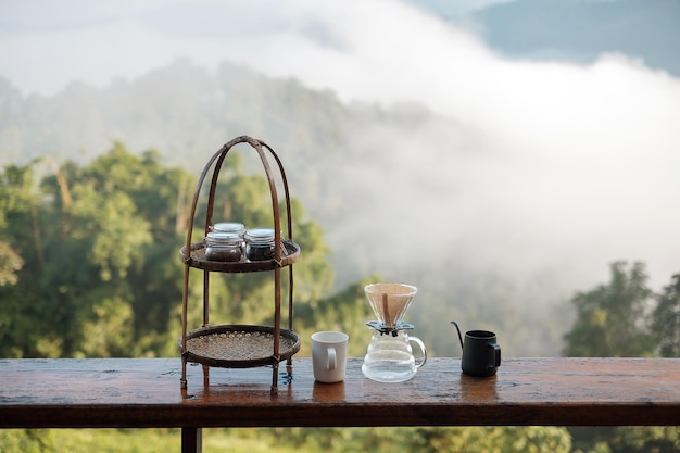 Arabica-Kaffeebrauen von Vintage-Kaffee-Tropf-Geräten auf Holztisch am Morgen mit Berg- und Naturhintergrund