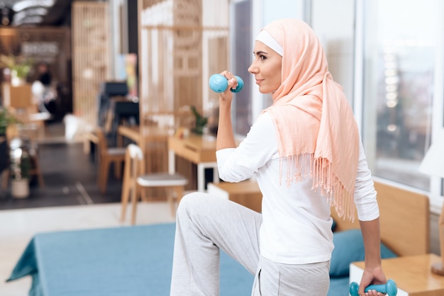 Arabische Frau, die Gymnastik im Schlafzimmer tut.