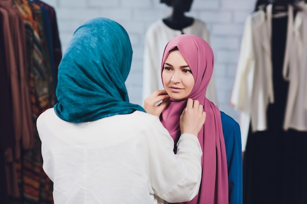 Foto arabische frau in traditioneller muslimischer kleidung kauft ein neues kleid in einem orientalischen laden