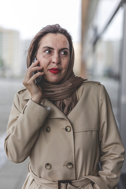 Arabische Frau mit Hijab am Telefon