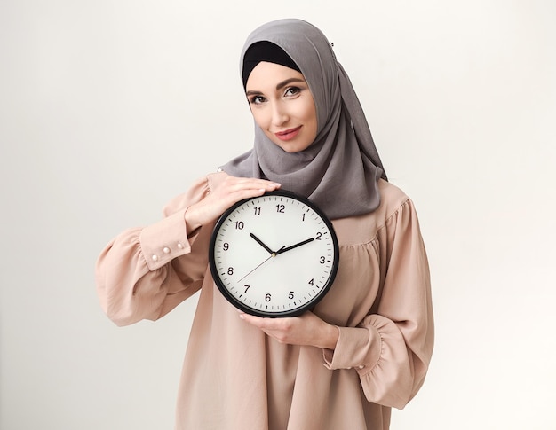 Arabische Frau mit Uhr auf weißem Hintergrund
